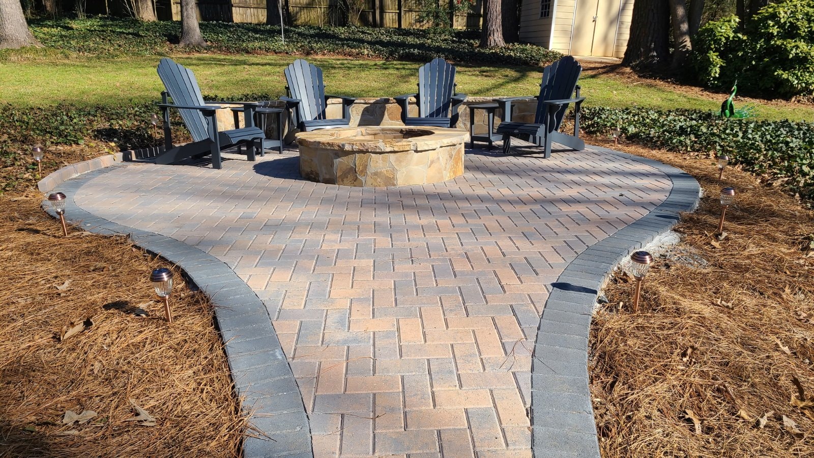 Holland herringbone paver patio with flagstone-veneered firepit